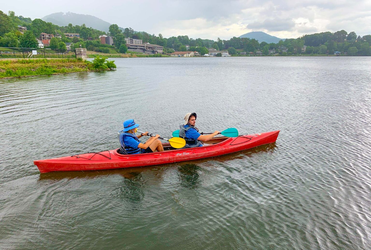 Friends enjoy paddling a double sit-inside kayak at Lake Junaluska