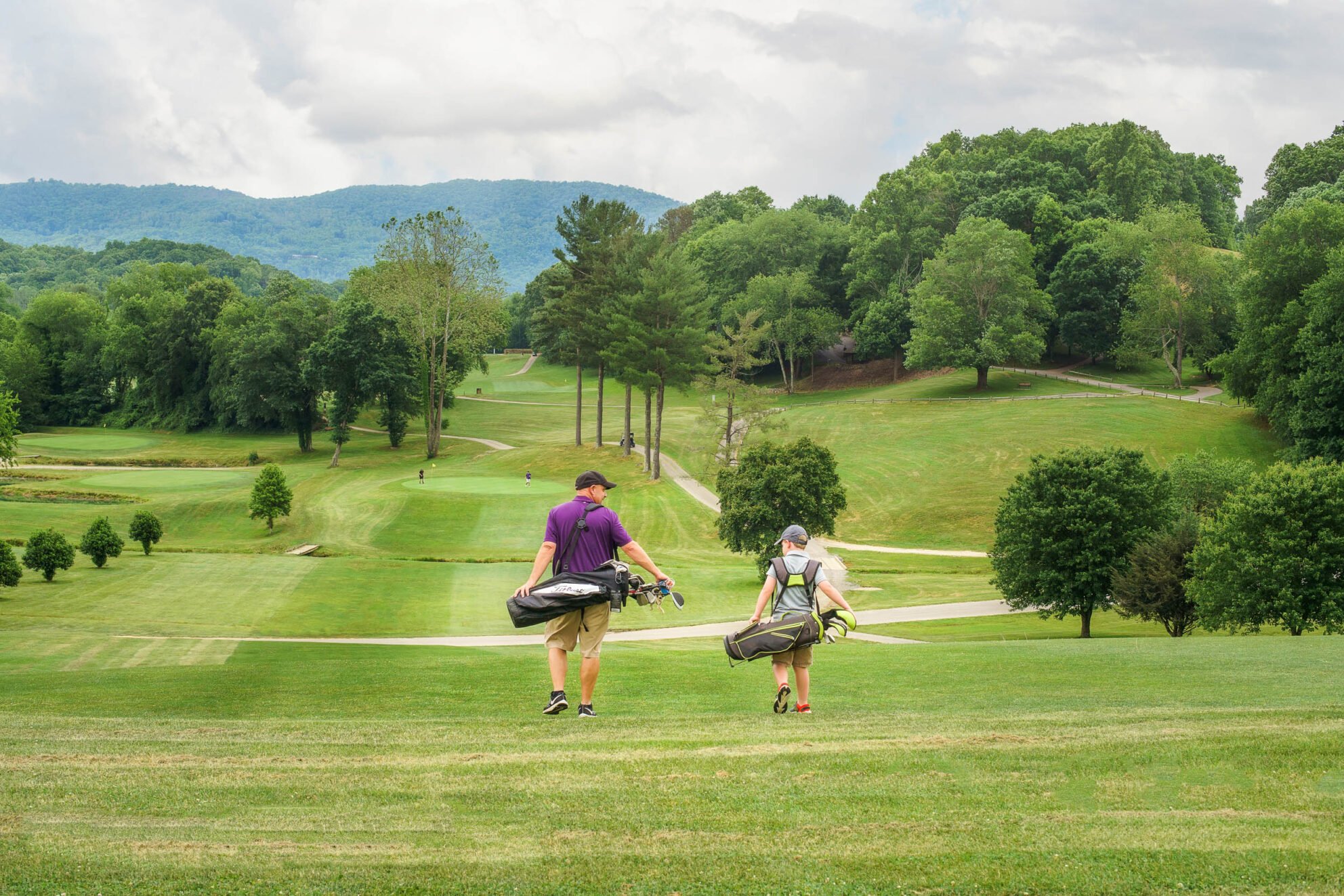 Father and son walking down the fairway of a Lake Junaluska Golf Course hole.