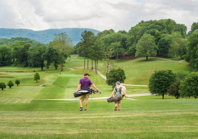 Father and son walking down the fairway of a Lake Junaluska Golf Course hole.