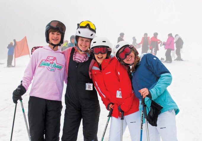 Friends downhill snowskiing pause for a photograph