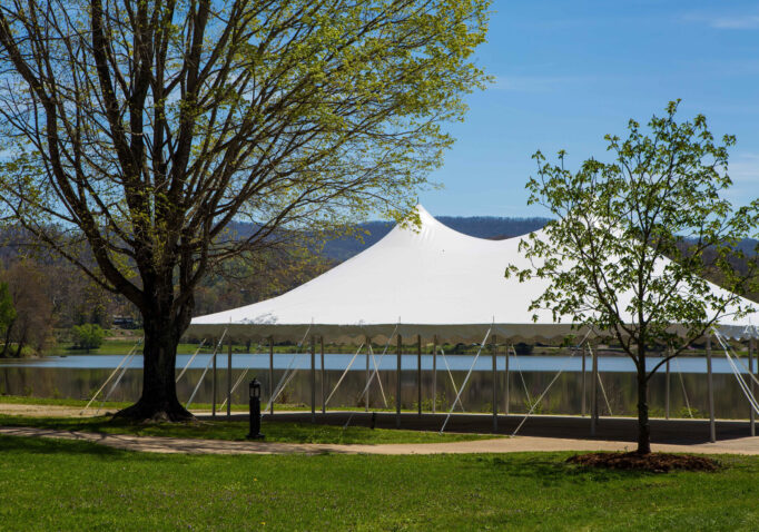White tent set up on greenspace beside Lake Junaluska