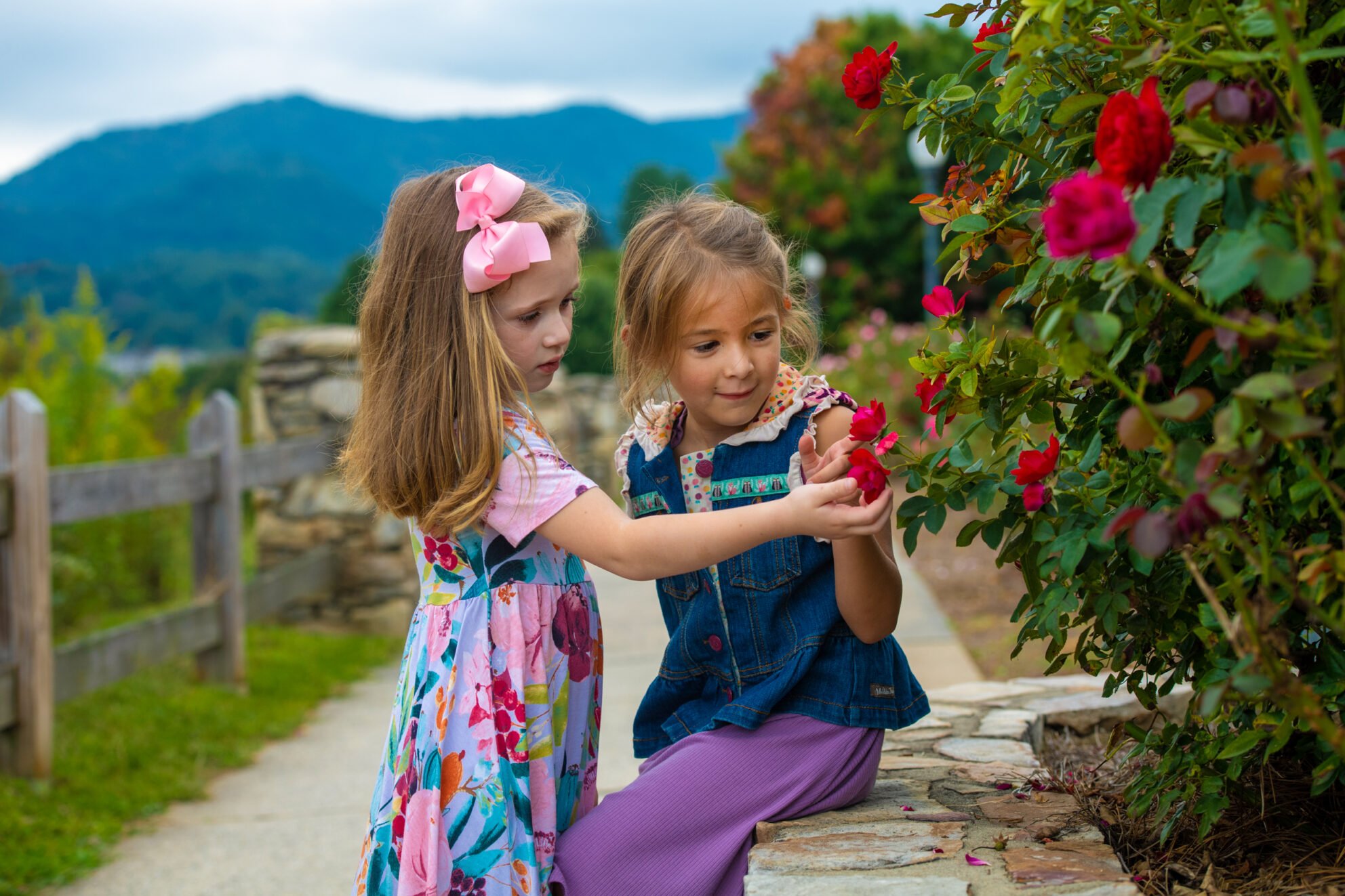 Two young girls looking at flowers on the Rose Walk trail at Lake Junaluska