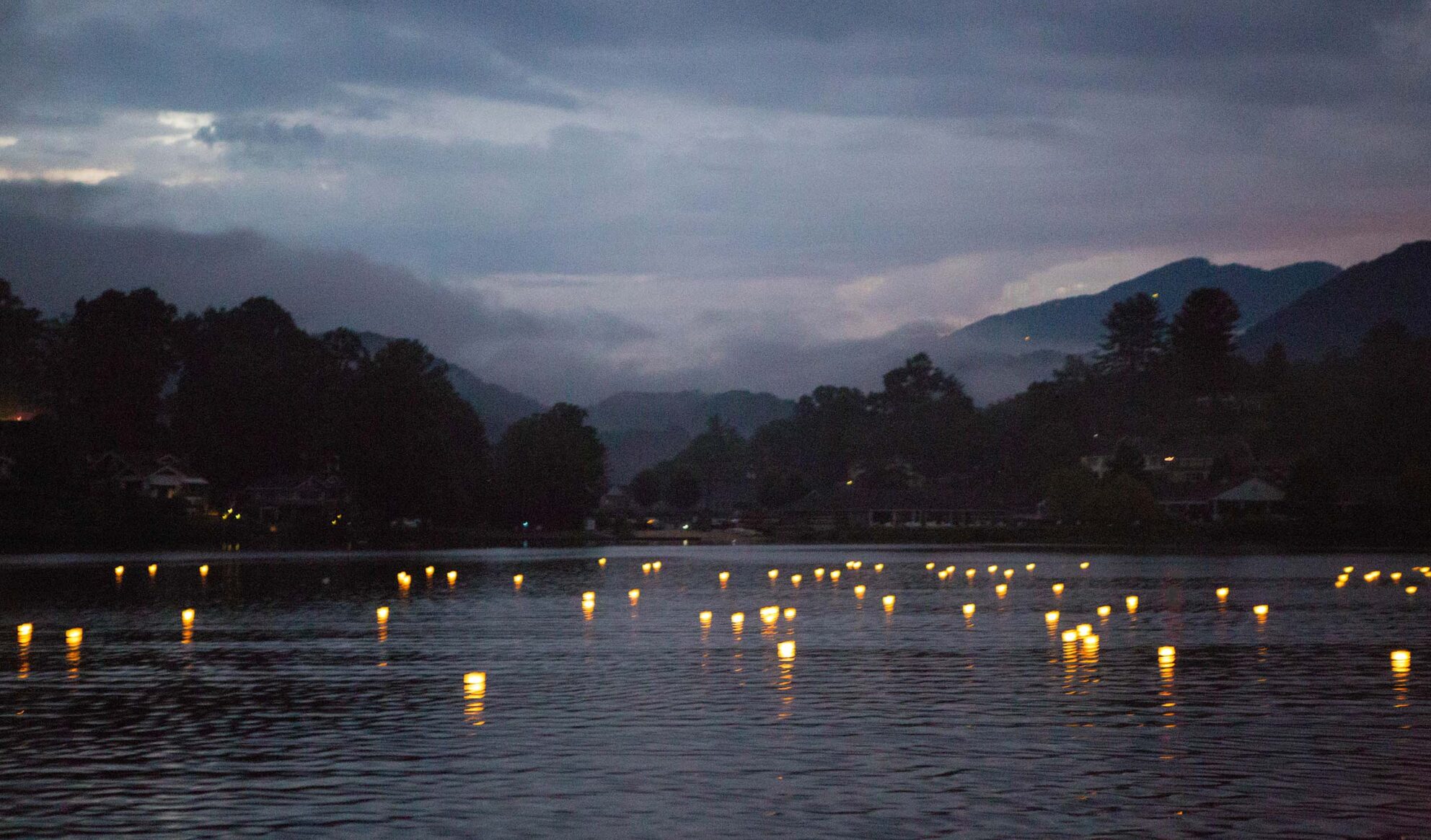 Floating wish lanterns cast glimmers of light on the water