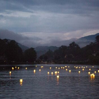 Floating wish lanterns cast glimmers of light on the water