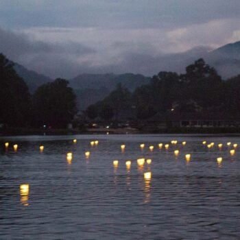 Floating wish lanterns cast glimmers of light on the water