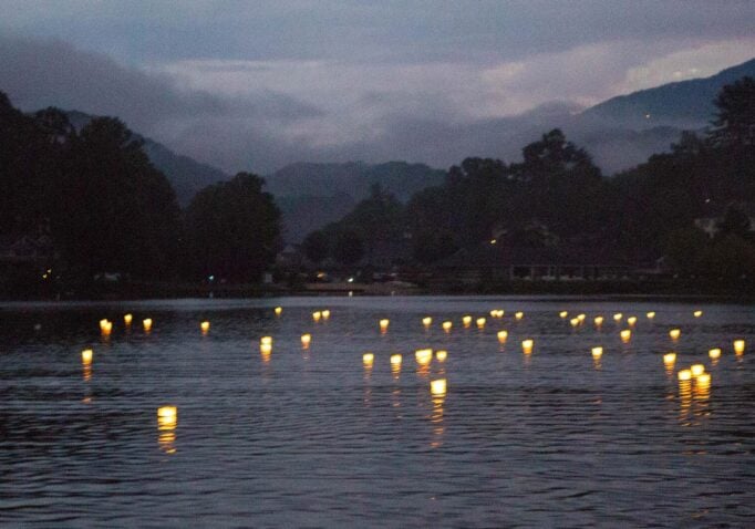 Floating wish lanterns cast glimmers of light on the water