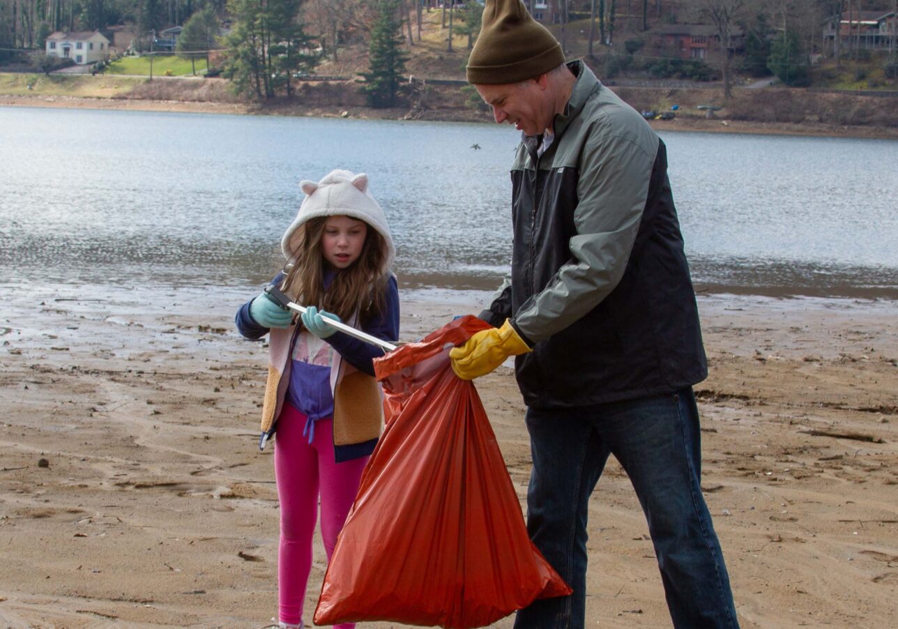 Lake clean up day volunteers pick up debris along the shoreline