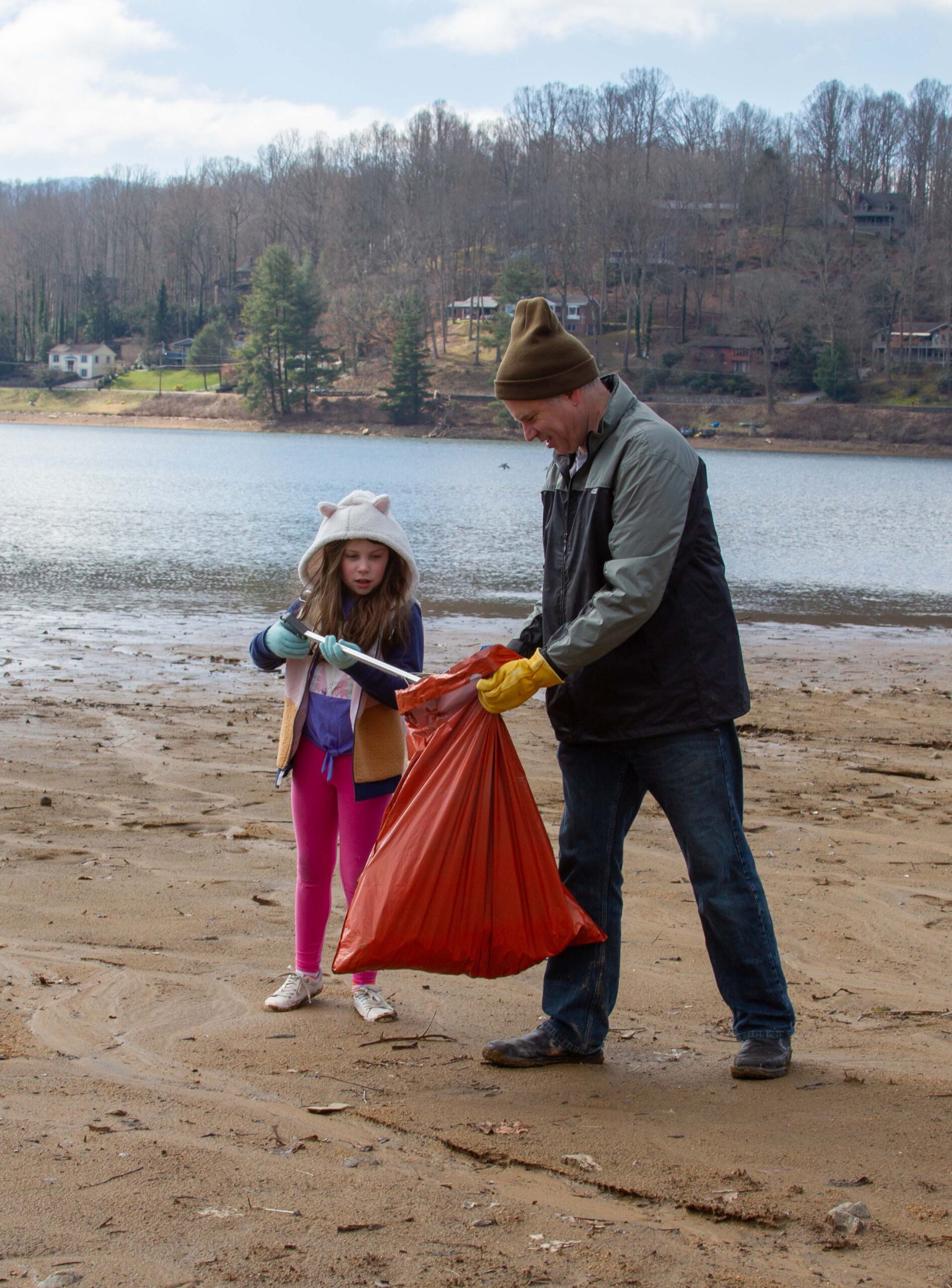 Lake clean up day volunteers pick up debris along the shoreline