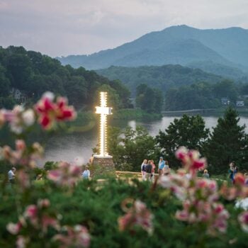 The light of the cross shines on a beautiful evening at Lake Junaluska