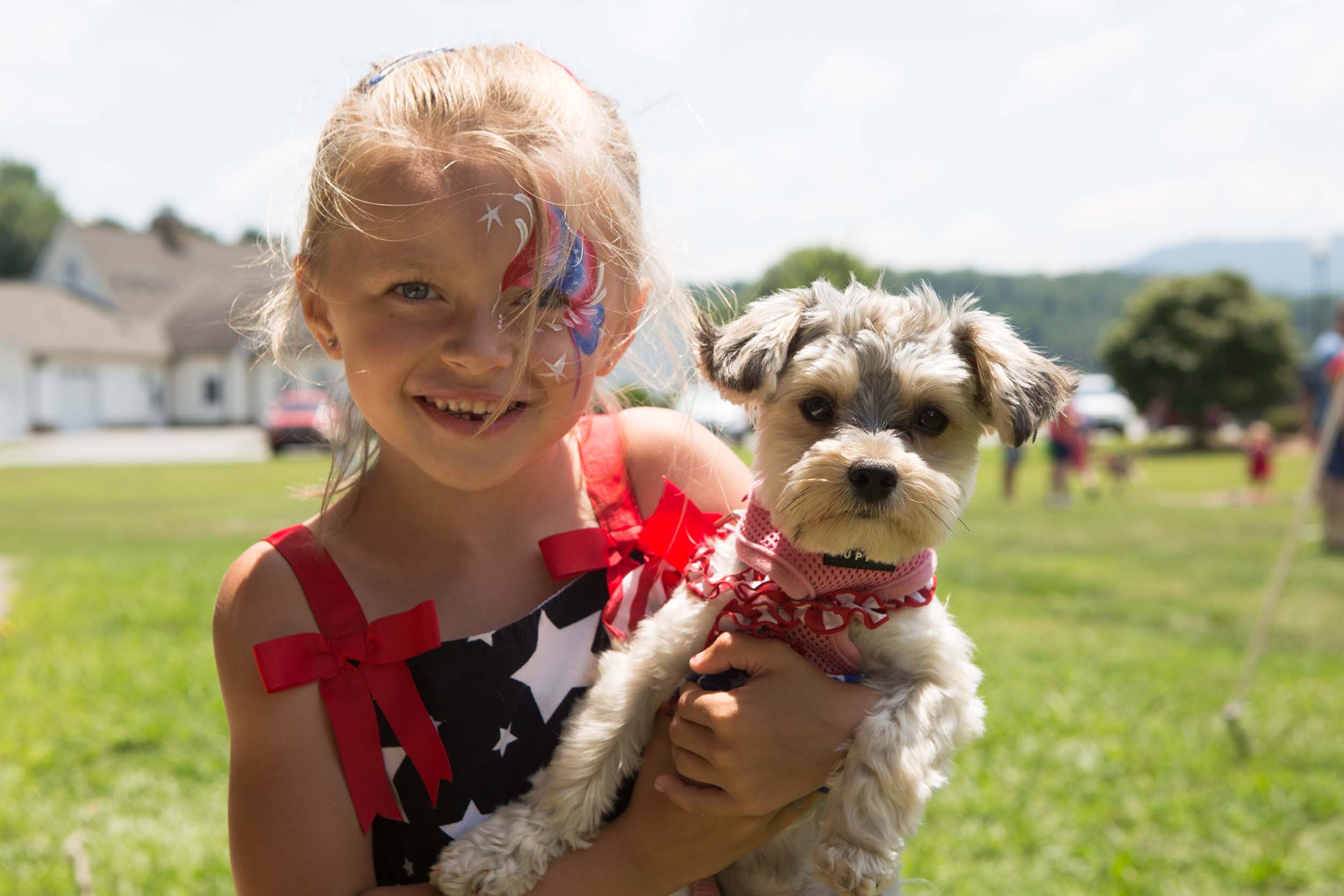 A girl holding a dog enjoys the Independence Day Celebrations at Lake Junaluska
