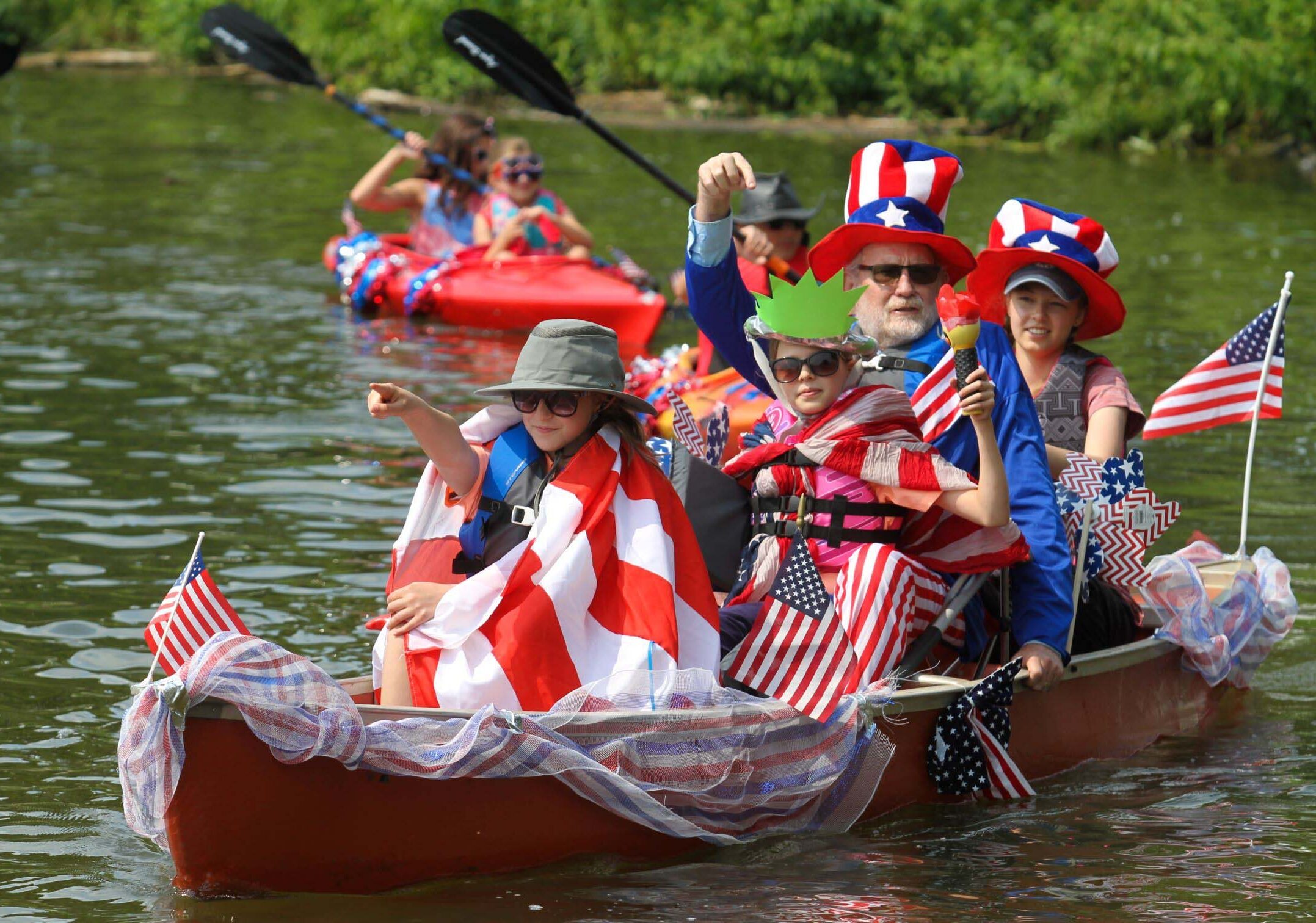 Participants in decorated kayaks and canoes participate in a flotilla parade as part of Independence Day Celebrations
