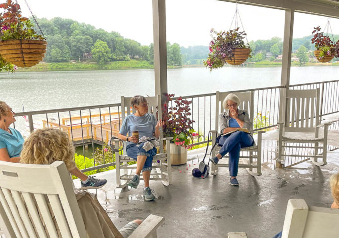 Participants in a morning devotion at Lake Junaluska sit in rocking chairs on the Harrell Center porch.
