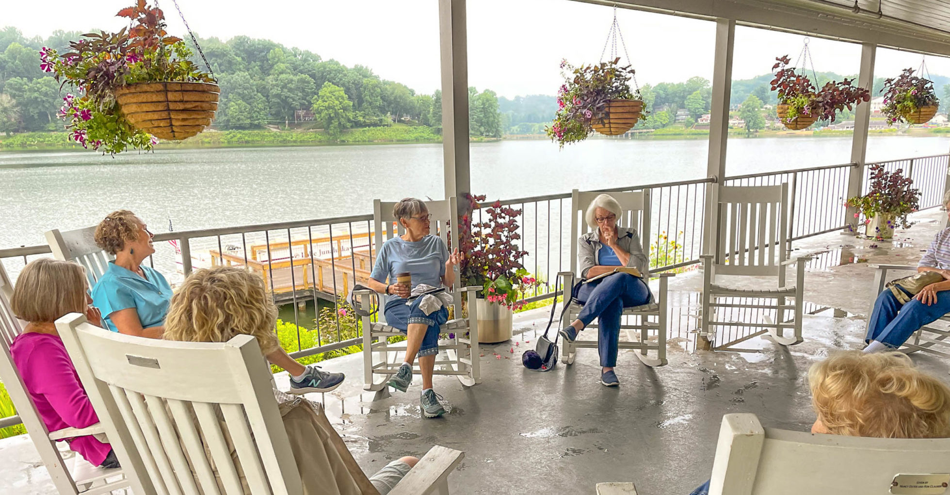 Participants in a morning devotion at Lake Junaluska sit in rocking chairs on the Harrell Center porch.