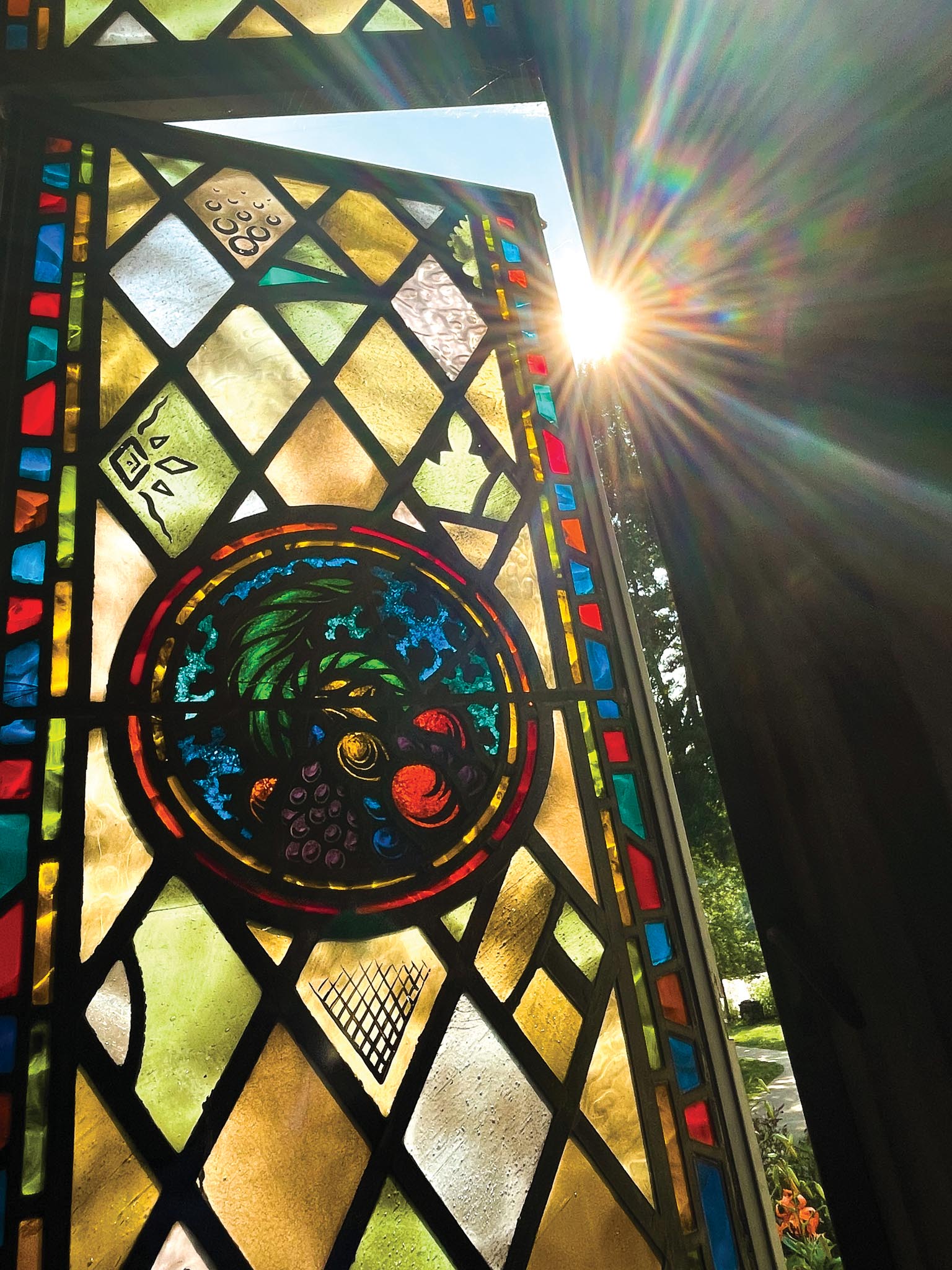 Sunlight shines through Memorial Chapel stained glass window.