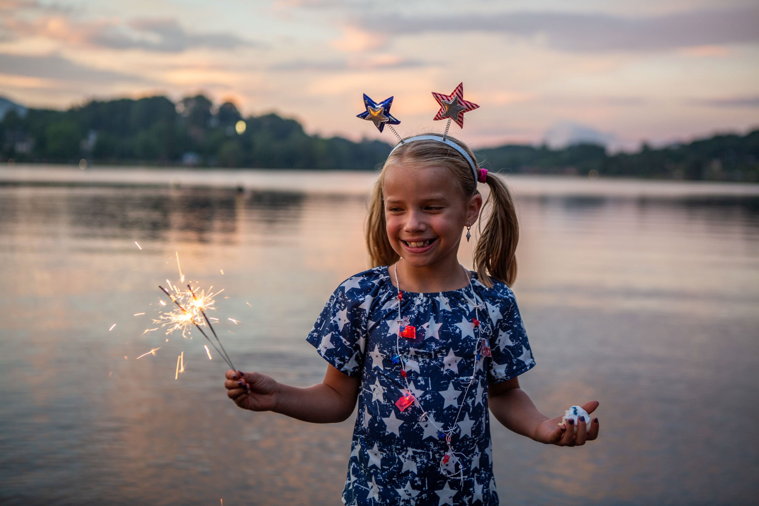 A girl enjoys a sparkler along the lakeshore before the fireworks show-1