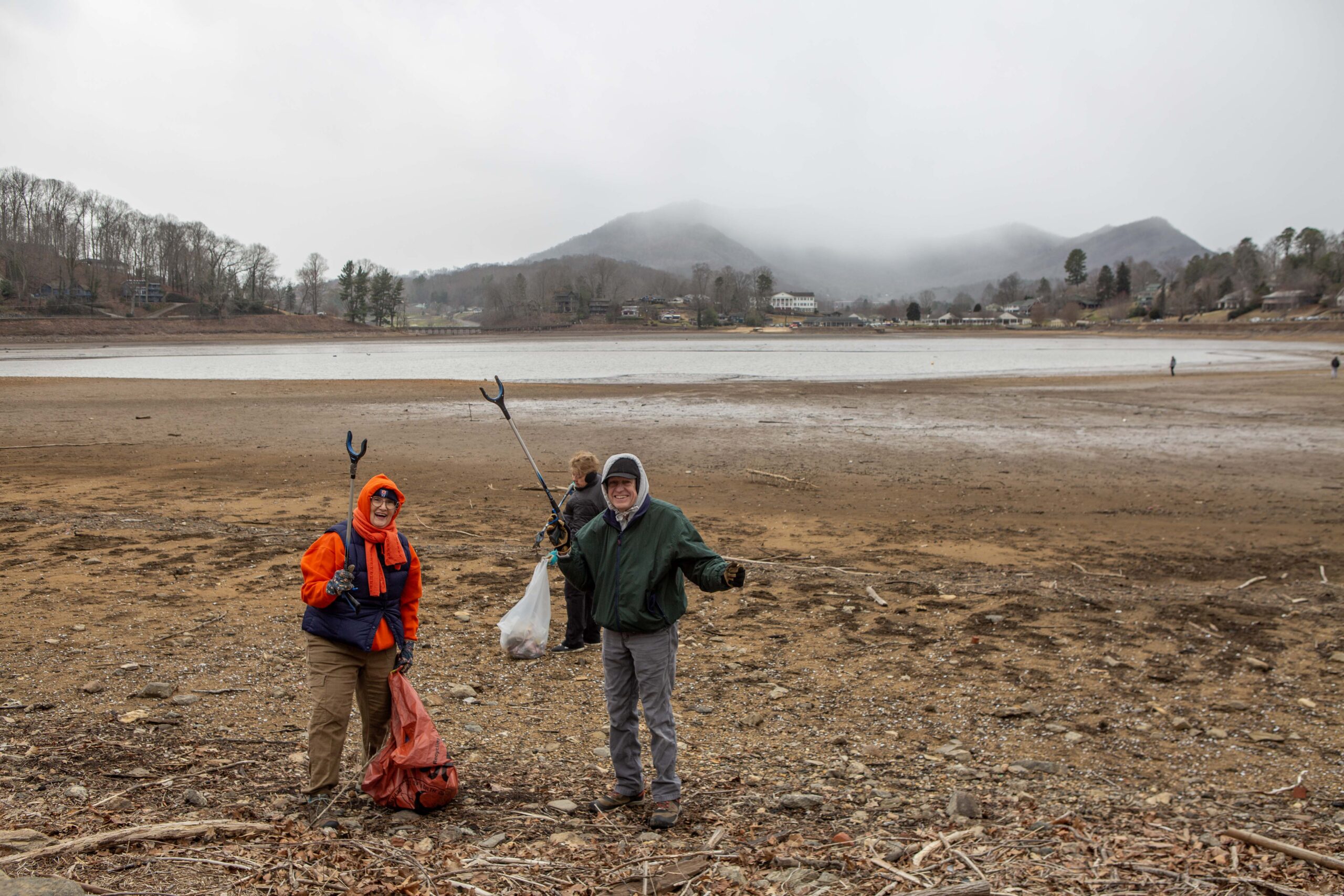 Volunteer walk along the lake bed to clean up debris during Lake Junaluska Clean up Day