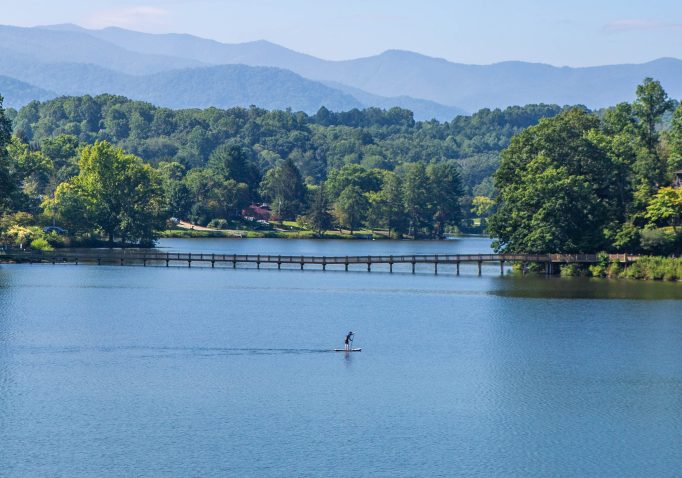 A single paddleboarder crosses the water at Lake Junaluska.