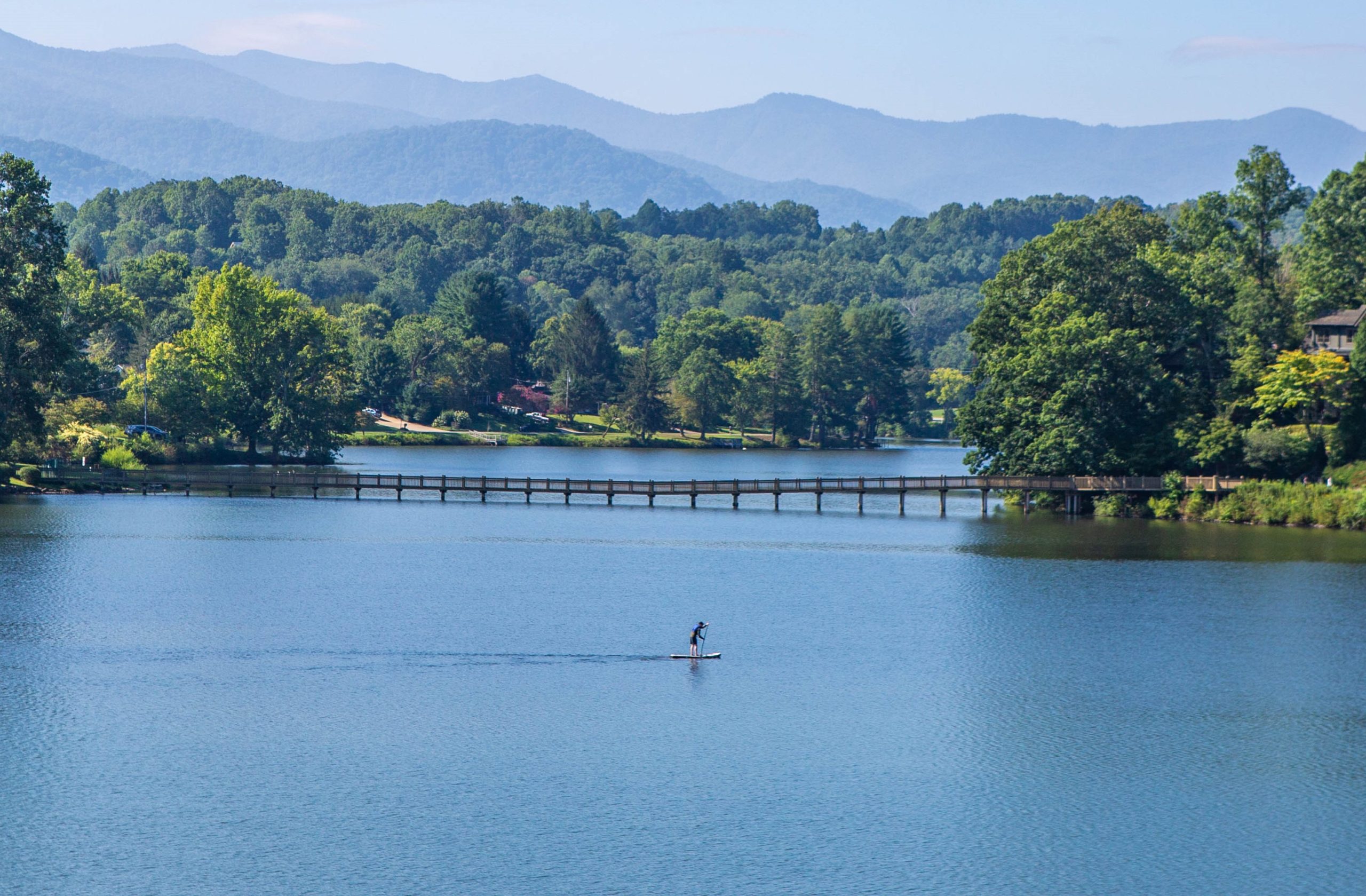 A single paddleboarder crosses the water at Lake Junaluska.